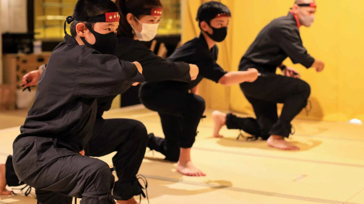 Children in ninja costume training with foam shuriken at a ninja museum in Tokyo