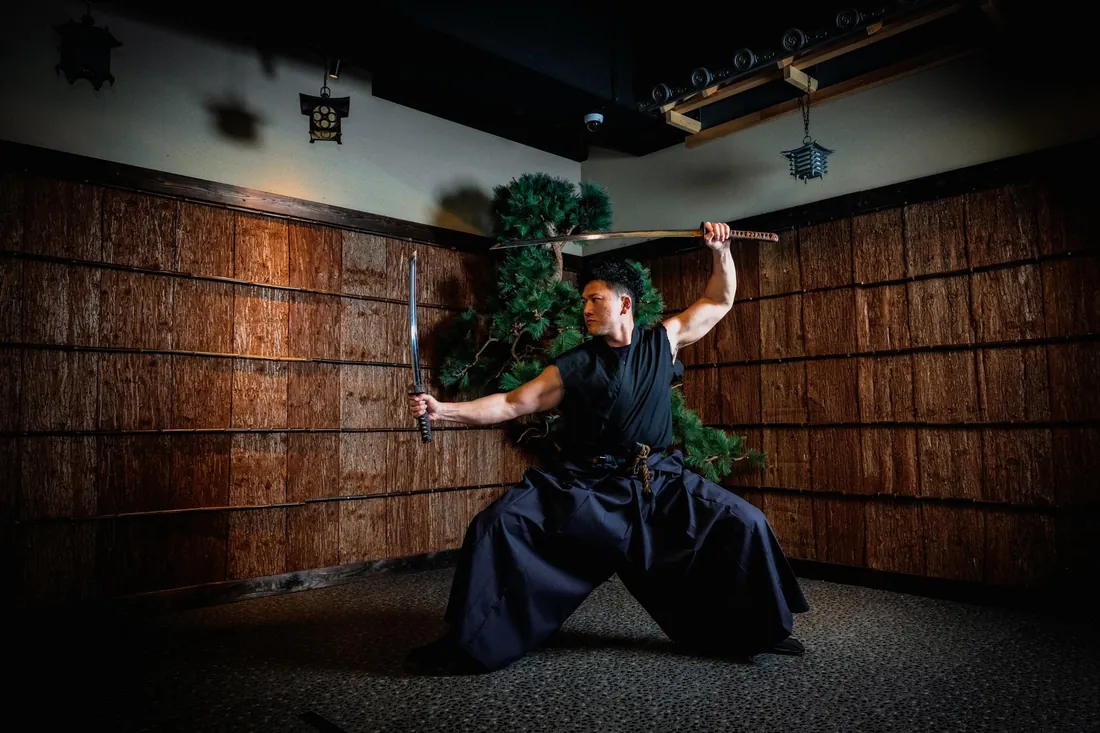 Instructor in hakama demonstrating a katana form during a sword lesson at the Samurai Ninja Museum Asakusa